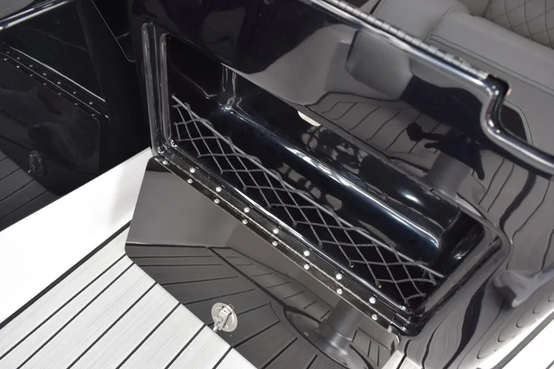 Slide: The Image of 2026 Yamaha Boats 222S storage compartment with sleek black finish and netting. - 17