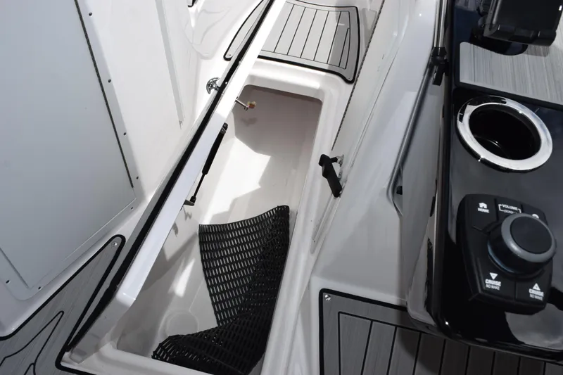 Slide: The Image of Interior view of 2026 Yamaha Boats 222S, showcasing storage compartment and control panel. - 19