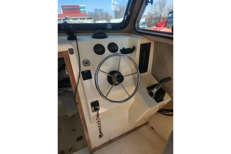 Slide: The Image of Steering wheel and controls of a 2000 Austin Parker 2520 Cabin boat. - 11