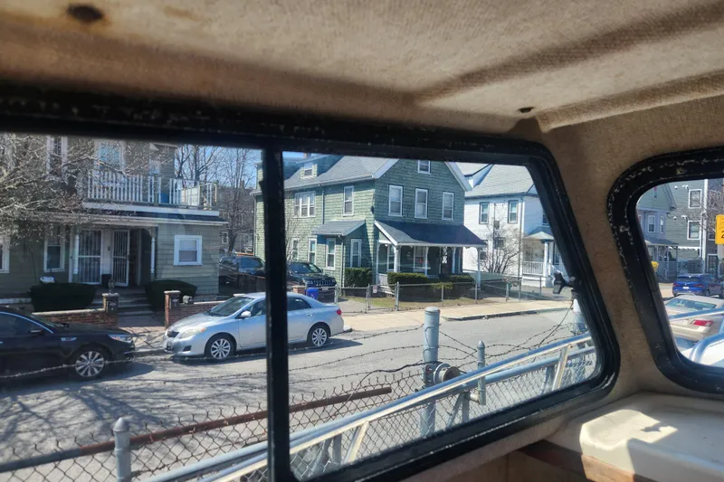 Slide: The Image of View from inside a 2000 Austin Parker 2520 Cabin, overlooking a suburban street with houses. - 13