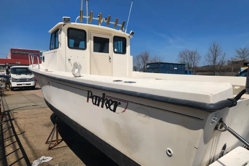 Slide: The Image of 2000 Austin Parker 2520 Cabin boat docked, featuring a white exterior and spacious cabin. - 3