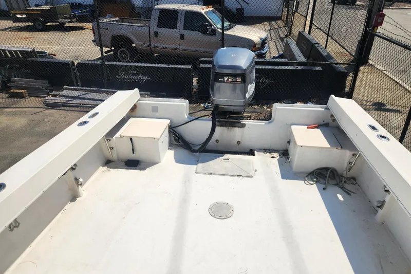 Slide: The Image of 2000 Austin Parker 2520 Cabin boat with V225 engine, docked in a fenced area. - 7