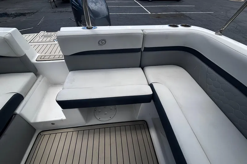 Slide: The Image of 2022 Hurricane SunDeck 217 OB boat interior with white cushioned seating and cup holders. - 12
