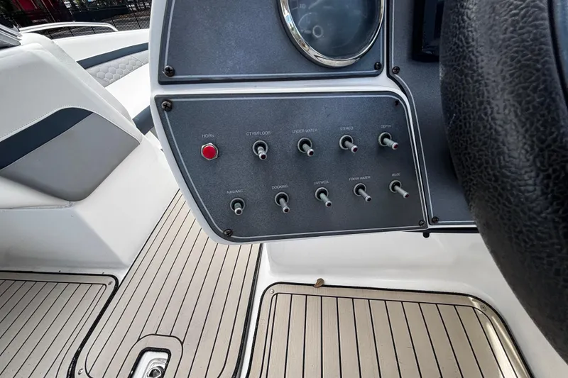 Slide: The Image of Control panel of 2022 Hurricane SunDeck 217 OB boat with switches and steering wheel. - 8