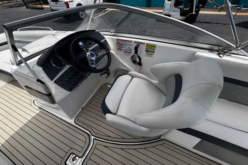 Slide: The Image of 2022 Hurricane SunDeck 217 OB boat interior with steering wheel and captain's chair. - 9