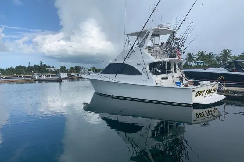 Slide: The Image of 1995 Ocean Yachts 42 Super Sport docked in a serene marina setting. - 1