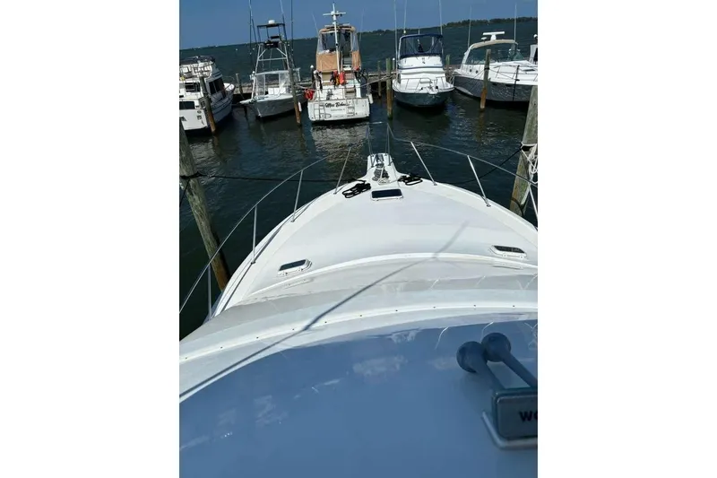 Slide: The Image of 1995 Ocean Yachts 42 Super Sport docked at a marina, surrounded by other boats. - 10