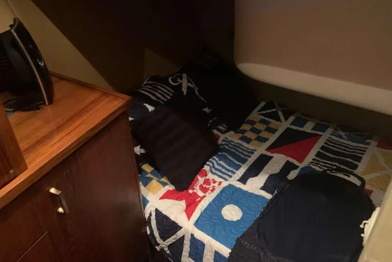 Slide: The Image of Cozy cabin interior of 1995 Ocean Yachts 42 Super Sport with nautical-themed bedding. - 16