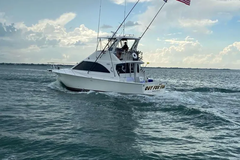 Slide: The Image of 1995 Ocean Yachts 42 Super Sport cruising on open water under a cloudy sky. - 2