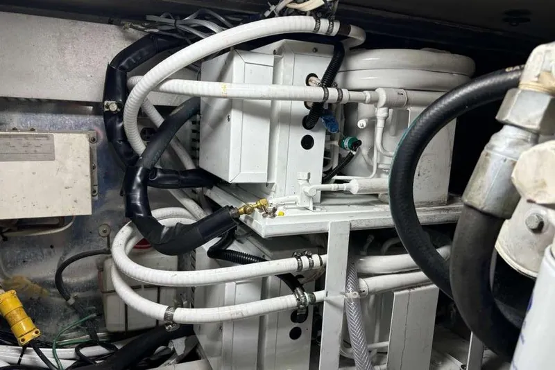 Slide: The Image of Engine room of a 1995 Ocean Yachts 42 Super Sport with visible hoses and machinery. - 27