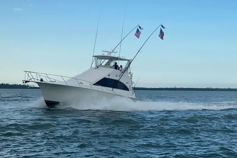 Slide: The Image of 1995 Ocean Yachts 42 Super Sport cruising on open water with flags flying. - 3