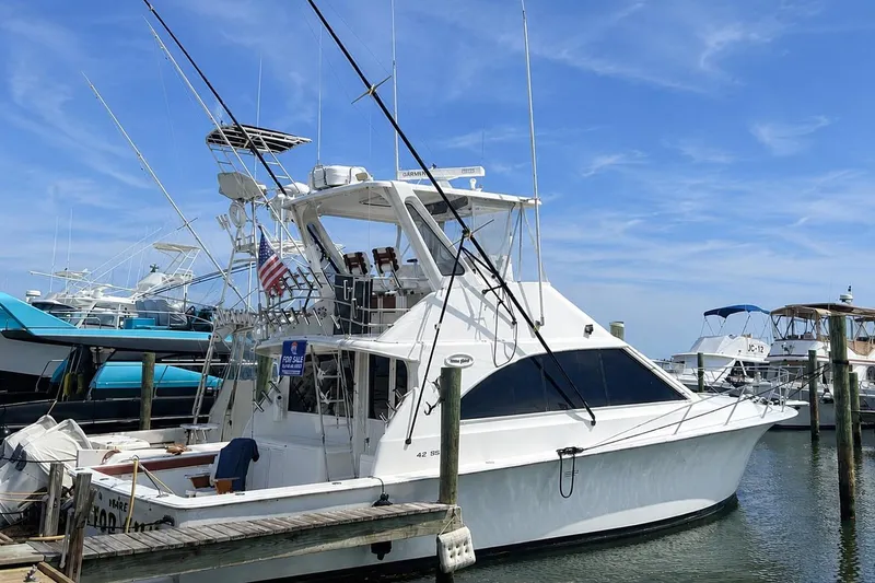 Slide: The Image of 1995 Ocean Yachts 42 Super Sport docked, featuring sleek design and fishing equipment. - 49