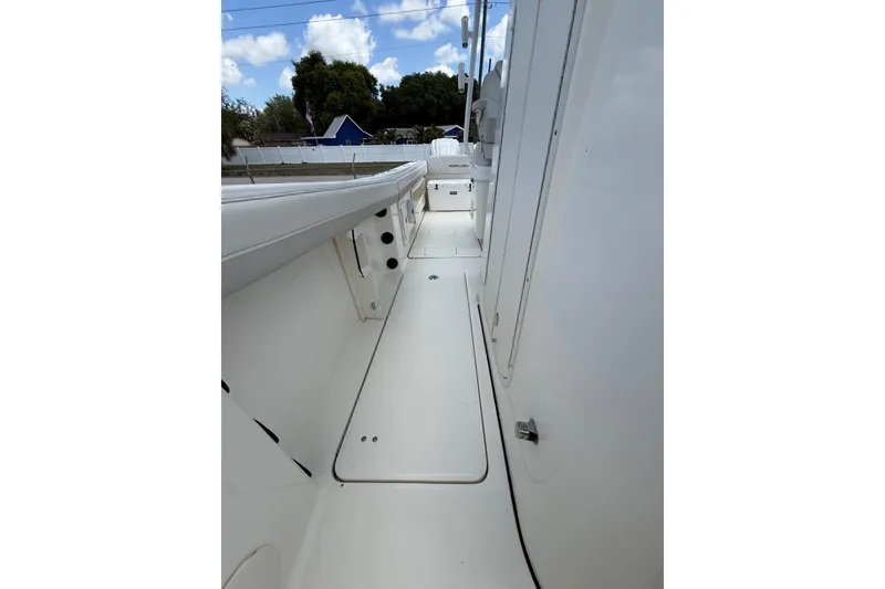 Slide: The Image of 2024 World Cat 295 CC boat deck, showcasing sleek white design and spacious walkway. - 11