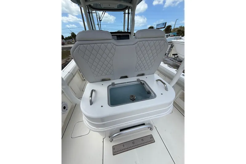 Slide: The Image of 2024 World Cat 295 CC boat interior with cushioned seating and storage compartment. - 15