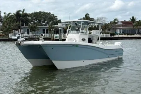 Slide: The Image of 2024 World Cat 295 CC boat on water, featuring sleek design and modern amenities. - 2