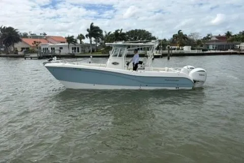 Slide: The Image of 2024 World Cat 295 CC boat on water, coastal background, partly cloudy sky. - 3