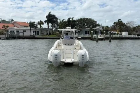 Slide: The Image of 2024 World Cat 295 CC boat on water near residential docks, under cloudy sky. - 5