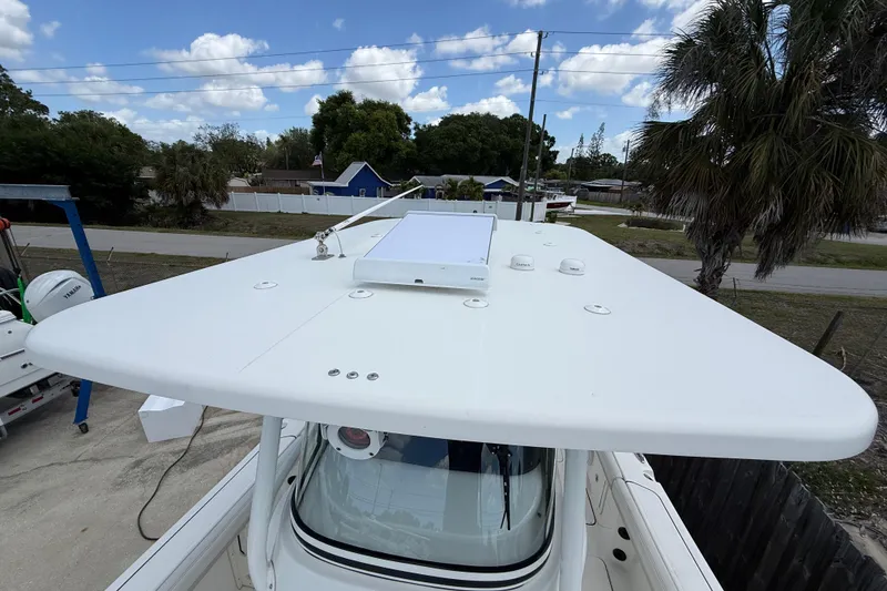 Slide: The Image of 2024 World Cat 295 CC boat with a sleek white hardtop under a blue sky. - 9