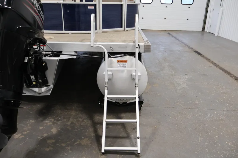 Slide: The Image of 2019 Bennington 20 SL pontoon boat with ladder and Mercury outboard motor in a garage. - 33