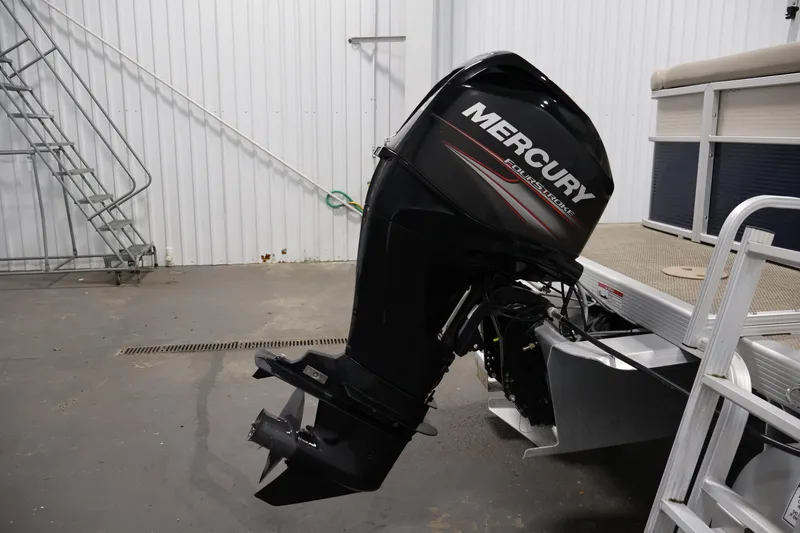 Slide: The Image of 2019 Bennington 20 SL with Mercury FourStroke outboard motor in a garage setting. - 34