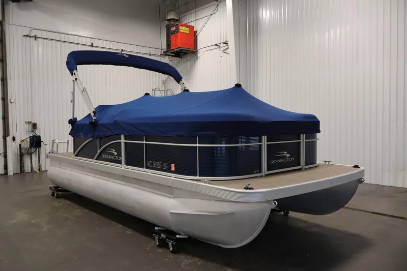 Slide: The Image of 2019 Bennington 20 SL pontoon boat with blue cover in indoor storage. - 38