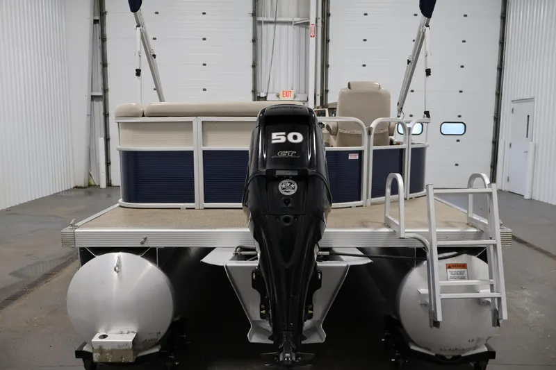 Slide: The Image of 2019 Bennington 20 SL pontoon boat with 50 HP engine in a garage setting. - 6