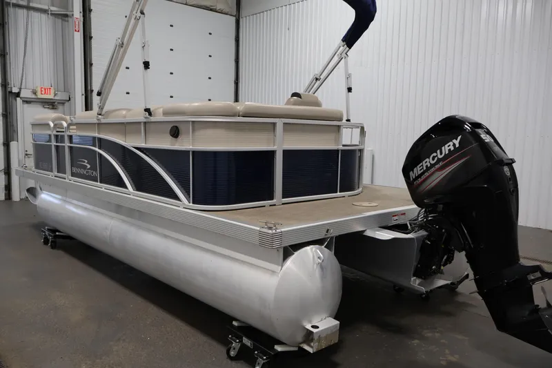 Slide: The Image of 2019 Bennington 20 SL pontoon boat with Mercury outboard motor in indoor storage. - 7