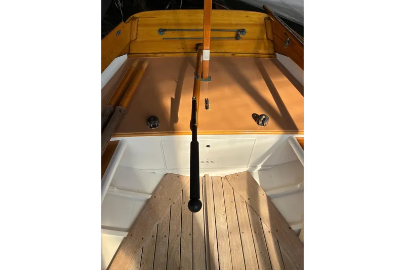 Slide: The Image of 1982 Herreshoff 12.5 footer sailboat cockpit with wooden tiller and deck details. - 11