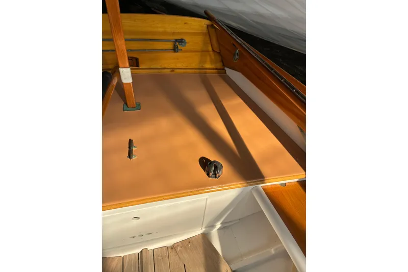 Slide: The Image of 1982 Herreshoff 12.5 footer sailboat deck with wooden details and fittings. - 12