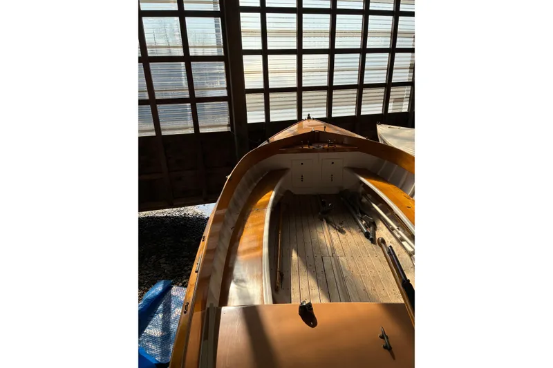 Slide: The Image of 1982 Herreshoff 12.5 footer sailboat in a sunlit boathouse. - 19