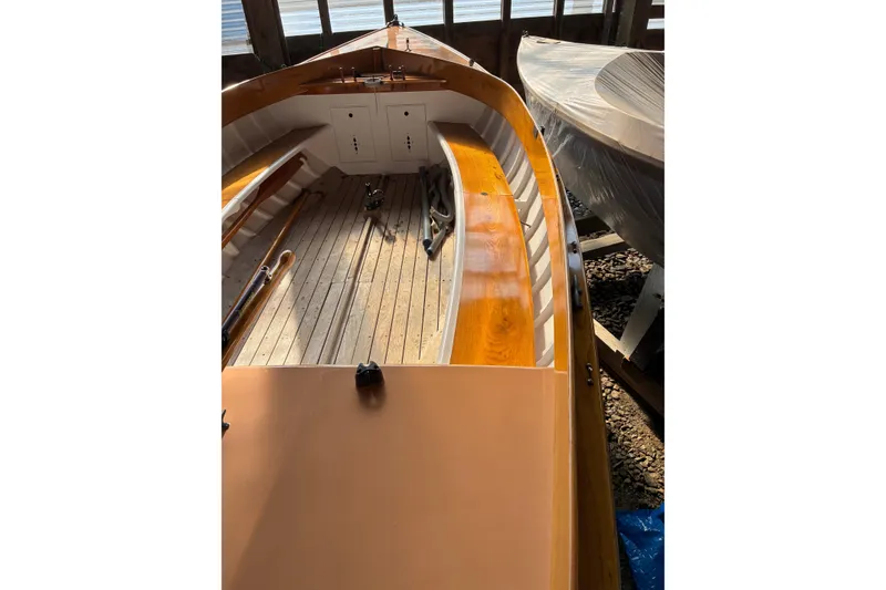 Slide: The Image of 1982 Herreshoff 12.5 footer sailboat interior with wooden deck and seating. - 20