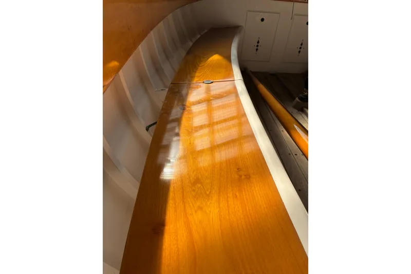 Slide: The Image of Interior view of a 1982 Herreshoff 12.5 footer sailboat with polished wooden surfaces. - 21
