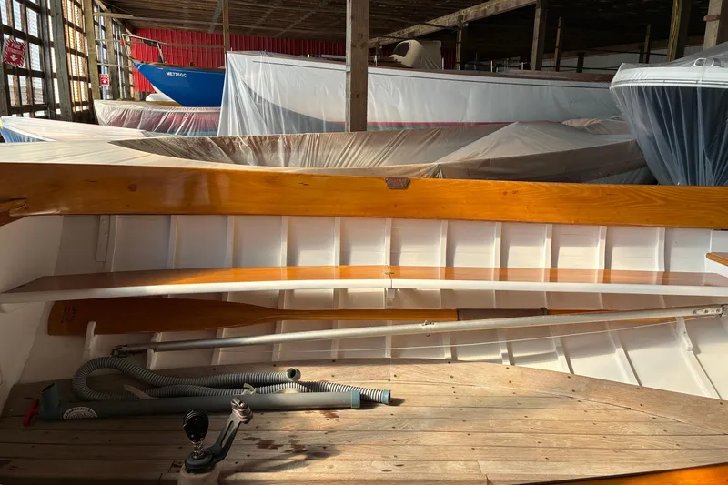 Slide: The Image of Interior of a 1982 Herreshoff 12.5 footer sailboat in storage, showcasing wooden details. - 22