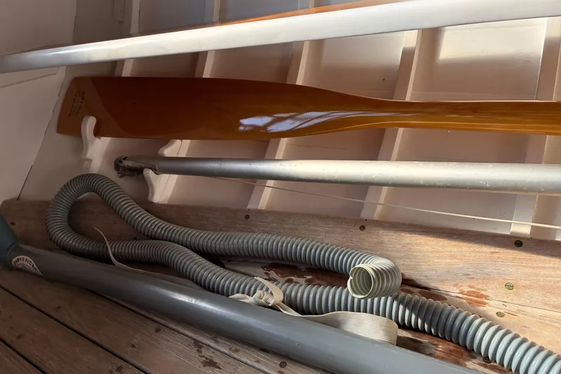 Slide: The Image of Interior of a 1982 Herreshoff 12.5 footer with oar and coiled hose. - 24