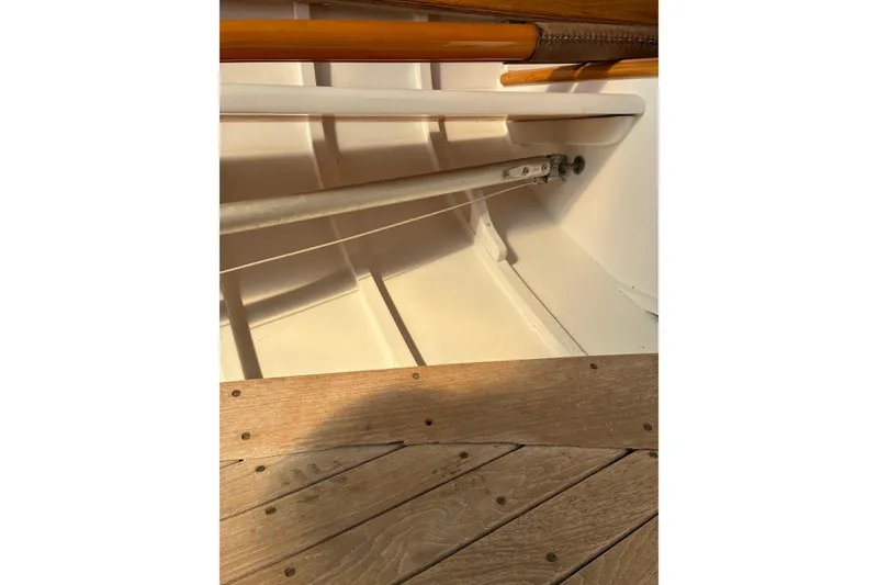 Slide: The Image of Interior view of a 1982 Herreshoff 12.5 footer sailboat, showcasing wooden and metal details. - 25