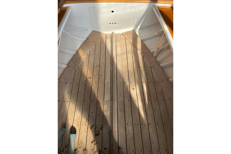 Slide: The Image of Interior view of a 1982 Herreshoff 12.5 footer sailboat with wooden flooring. - 26