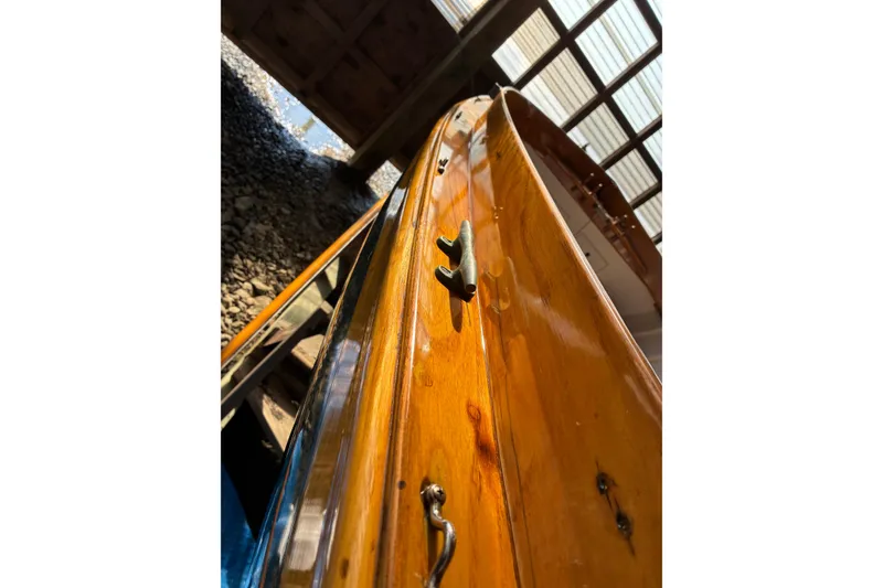 Slide: The Image of Close-up of a 1982 Herreshoff 12.5 footer's polished wooden hull detail. - 30