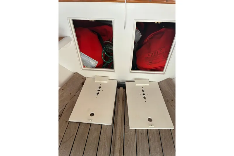 Slide: The Image of Storage compartments on a 1982 Herreshoff 12.5 footer, containing life jackets and ropes. - 9