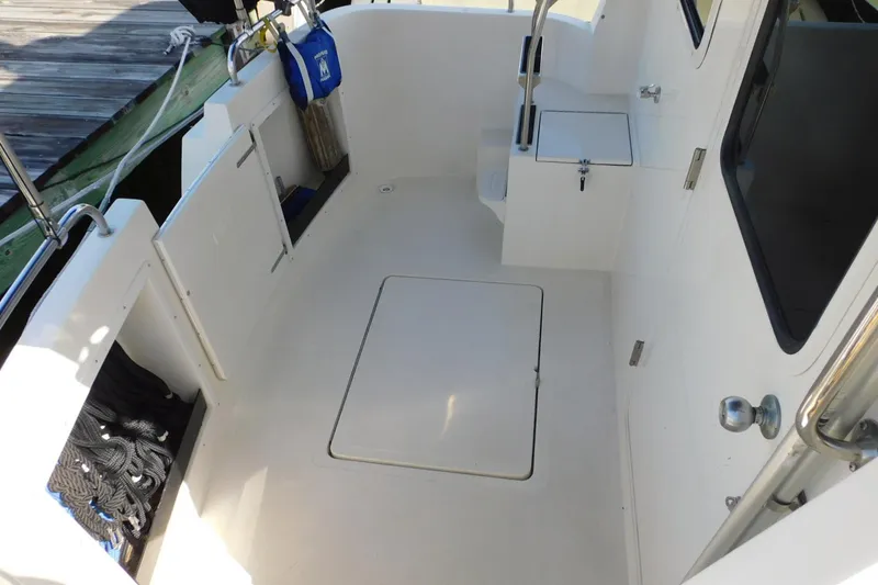 Slide: The Image of 2000 Camano Troll boat deck with storage hatch and dockside view. - 10