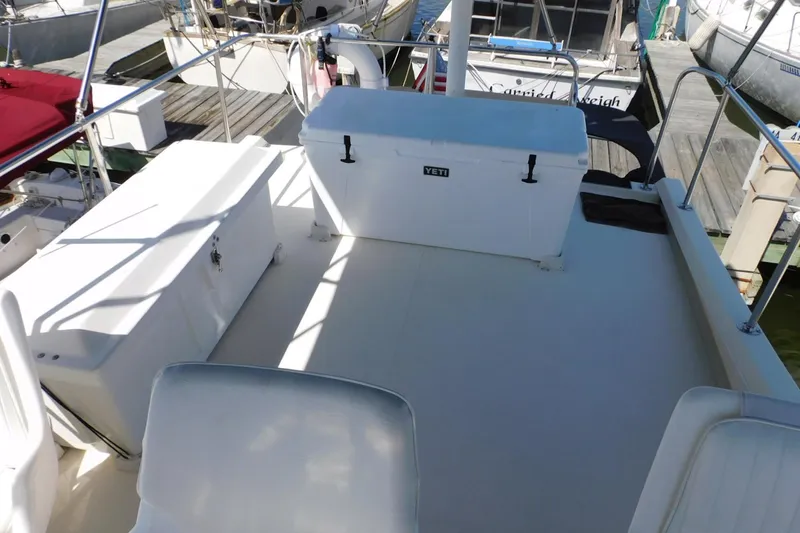 Slide: The Image of Deck of a 2000 Camano Troll boat with seating and a Yeti cooler. - 16