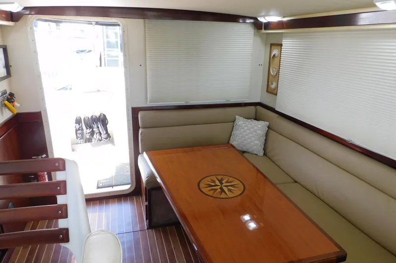 Slide: The Image of Interior of a 2000 Camano Troll boat with a cozy dining area and wooden table. - 19