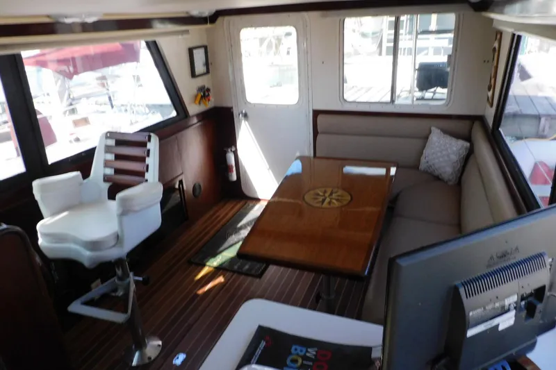 Slide: The Image of Interior of a 2000 Camano Troll boat with seating, table, and helm chair. - 21