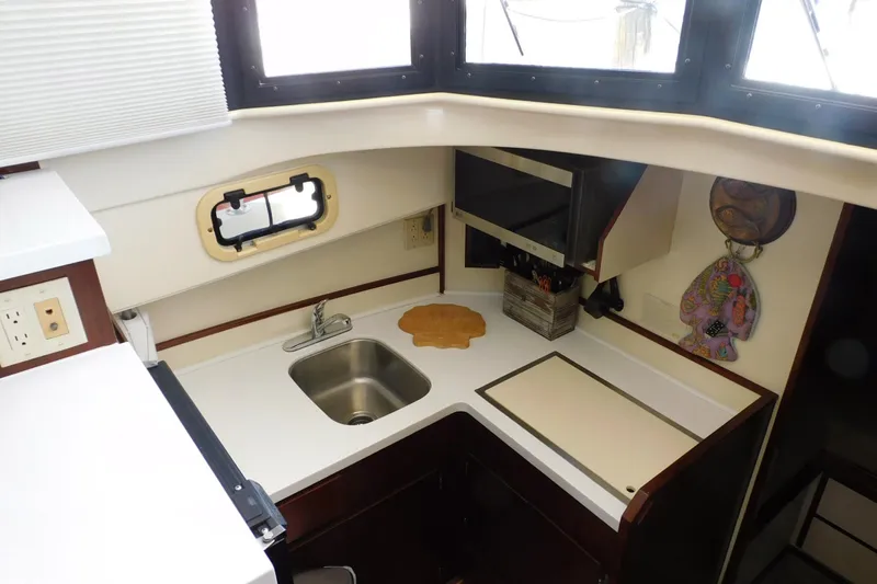 Slide: The Image of Compact kitchen area in a 2000 Camano Troll boat with sink and microwave. - 23