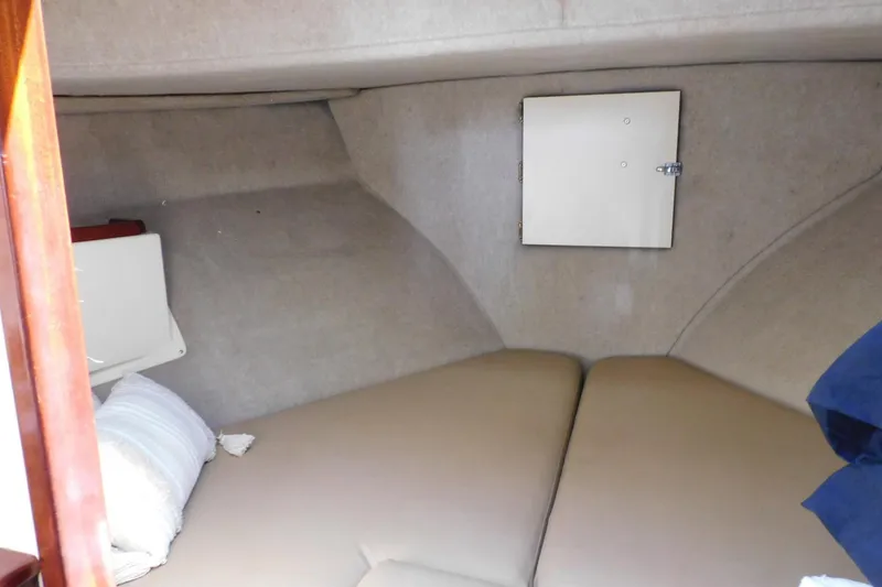 Slide: The Image of Interior cabin of a 2000 Camano Troll boat with beige cushions and storage compartment. - 28