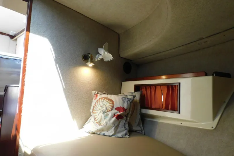 Slide: The Image of Cozy interior of a 2000 Camano Troll boat with nautical-themed pillow and warm lighting. - 29