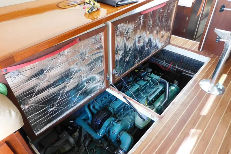 Slide: The Image of Engine compartment of a 2000 Camano Troll boat, showcasing mechanical components and insulation. - 32
