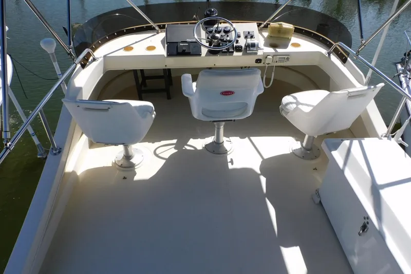 Slide: The Image of 2000 Camano Troll boat helm with three white captain chairs and steering controls. - 38