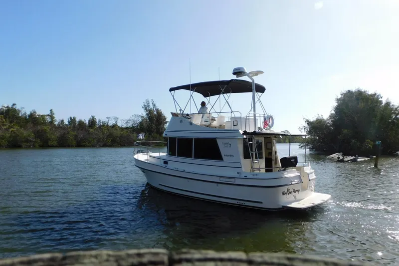 Slide: The Image of 2000 Camano Troll boat cruising on a serene river with lush greenery. - 4
