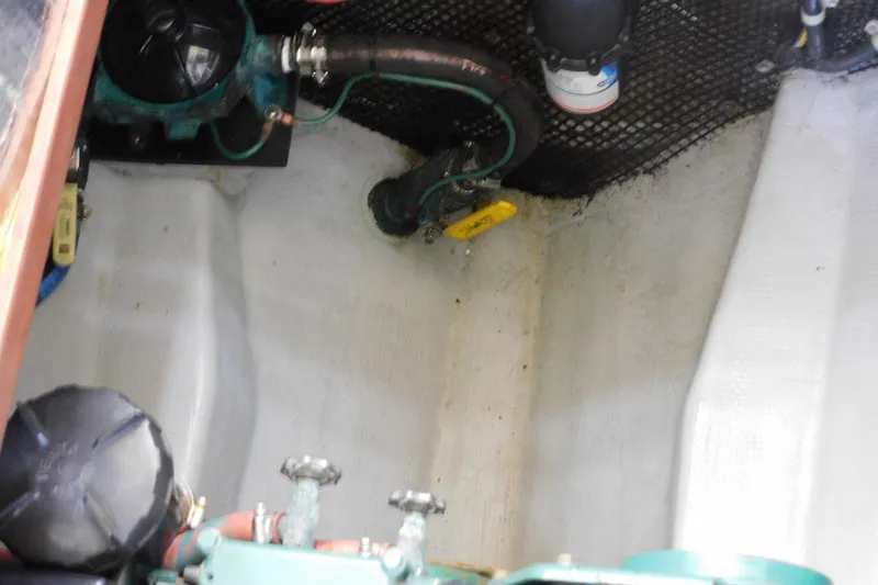 Slide: The Image of Engine compartment of a 2000 Camano Troll boat, showing mechanical components and hoses. - 42