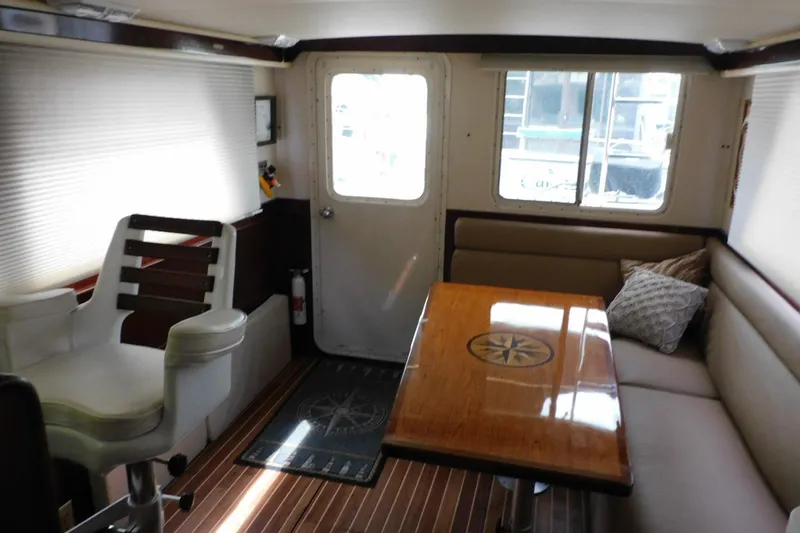 Slide: The Image of Interior of 2000 Camano Troll boat with seating, table, and captain's chair. - 44